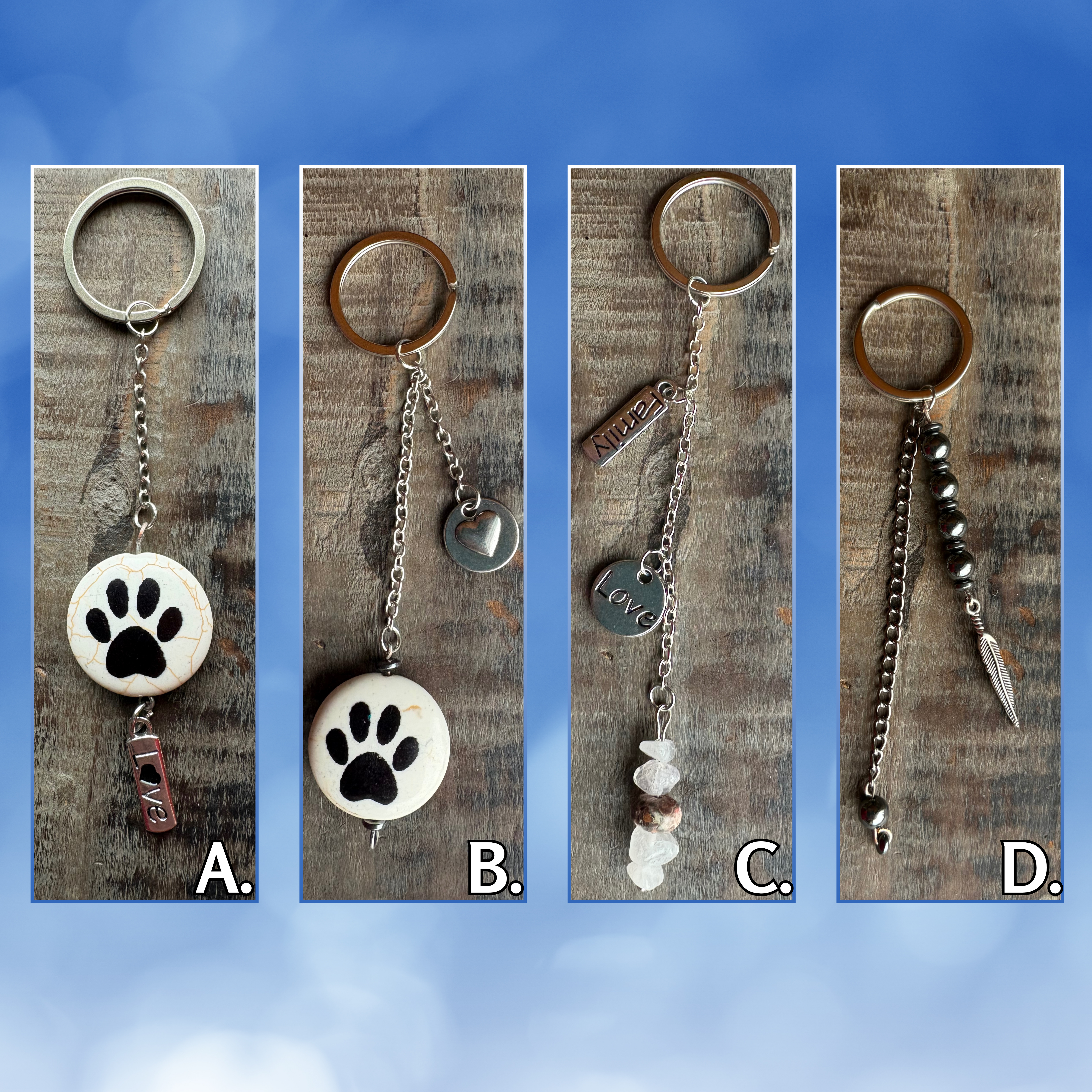 Photo of 4 different handmade keychains. The first two have a large lentil shaped reconstituted stone bead with a black paw print on the front and back and a "love" charm, the third has 4 rose quartz stones and 1 leopard jasper stone with "love" and "family" charms, the fourth has a metal feather charm with hematite stones. 